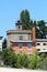 Red building blocks new unfinished part of old dilapidated fire station with vintage siren on top surrounded with gravel parking