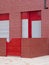 Red building facade with patio.