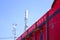 A red building with a signal booster above it and a clear blue sky