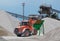 Red bulldozer at work on a green hopper under the conveyor belts in a gravel pit