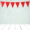 Red bunting party flag with heart shape pattern hanging over green wall and perspective white wood background