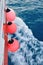 Red buoy on body of moving ship
