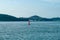 Red buoy floating in the sea with seascape and landsacpe in background. The ship traveling along the ocean with cityscape and