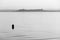 A red buoy on Trasimeno lake at sunset, with Castiglione del Lag