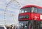 Red bus crossing the Westminster bridge at London city and the huge ferris wheel London Eye