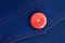 Red button on blue textile
