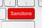 Red button with sanctions word on the keyboard