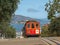 A red cable car with a distant alcatraz island in san francisco