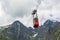 Red cable car with tourists in the Tatra mountains on the route Skalnate pleso - Lomnica peak.