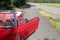 Red cabriolet is parked at the street