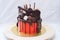 Red cake with melted chocolate, marshmallow, candies, toffees, guitars, donuts, cake pops and stars decoration.