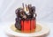 Red cake with melted chocolate, marshmallow, candies, toffees, guitars, donuts, cake pops and stars decoration.