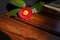 A red camellia flower placed on an auburn wood chair