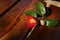 A red camellia flower placed on an auburn wood chair