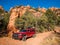 Red camper pickup truck on red gravel road in Utah canyon