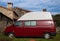 Red camper van parked on the grass in a rural setting