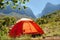 Red camping tent in misty mountains