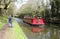 Red canal boat and walker on towpath Lancaster canal