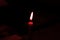 The red candle with beautiful flame in hand