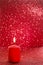 Red candle. Red glittering christmas lights. Blurred abstract ba