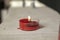 Red candle stands on a board