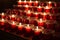 Red candles in the church. Row of glowing candles. Candlelight in the night. Christmas holiday background.