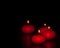 Red candles with flame on wood and black background, dark atmospere