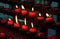 Red candles with yellow flame on catholic church altar. Burning candle closeup photo. In memoriam banner template