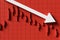 Red candlestick background image with a downward pointing arrow indicating a falling stock price. 3d