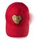 Red cap with golden sequin heart patch on white background