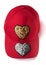Red cap with golden and silver sequin heart patches on white background