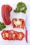 Red capsicum peppers on white wood table.