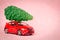 The red car is carrying the tree. Christmas candle