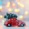 Red car with Christmas tree on roof on bright lights background.  Christmas motif.