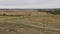 a red car drives around a large puddle on a country road in a field. Autumn landscape, cloudy day