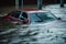 Red car drowning in flood water