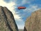 Red car jumping over a cliff between stone elevations