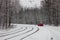 Red car near the tram line rails in the snow-covered forest in Kiev. Ukraine