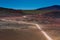 Red car on road in dry landscape leading to Reunion Island volcano