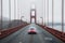 A red car is seen driving across a bridge on a foggy day, with the mist creating a mysterious atmosphere, A sports car traveling