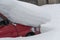 Red car under pile of snow. Unexpected snowfall, danger on road