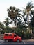 Red car van taxi in Thailand against the backdrop of palm trees