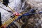Red carabiner, climbing rope and equipment on the rock and stream
