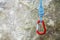 Red carabiner with climbing rope on rocky background