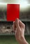 Red card with hand from referee giving a penalty