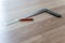 Red Carpenter`s Pencil and Right Angle`s Tool on Laminate Floor