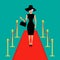 Red carpet and rope barrier golden stanchions turnstile Woman in black hat, bag, sunglasses waving. Rich beautiful celebr