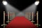 Red carpet and rope barrier with shining spotlights