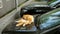 Red cat lies on the hood of the car and licks itself.