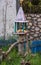 A red cat sleeps in a bird feeder. Rural landscape with a cat